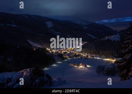 Schöne österreichische Stadt im Alpental beleuchtet bei Nacht (Filzmoos, Salzburger Land) Stockfoto