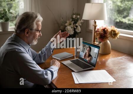 Reifer Mann trägt eine Brille, die einen Videoanruf bei einer erwachsenen Tochter macht Stockfoto