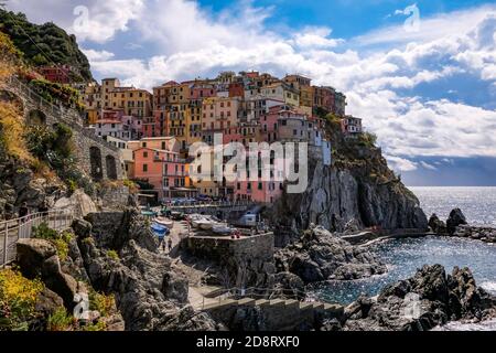 Klassische Ansicht von Manarola, Cinque Terre, Italien - Bunte Häuser in einer dramatischen Felsformation am Meer mit einem natürlichen Fischerhafen Stockfoto