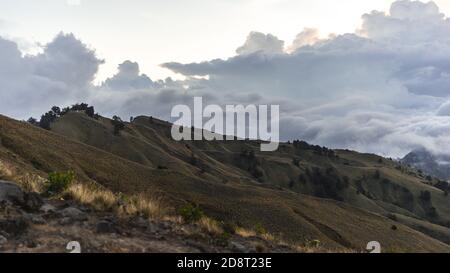 Landschaft mit Wolken, Bergpanorama am Morgen, Sonnenaufgang über den Hügeln und Bergen mit flauschigen Wolken, Lombok Island, Indonesien Stockfoto