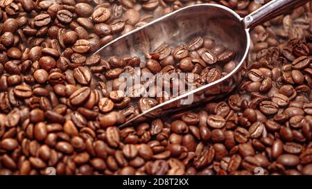 Nahaufnahme von Kaffeesamen. Duftende Kaffeebohnen sind gerösteter Rauch kommt von Kaffeebohnen. Stockfoto