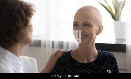Nahaufnahme Pflege Arzt berühren lächelnd haarlose Frau Schulter Stockfoto
