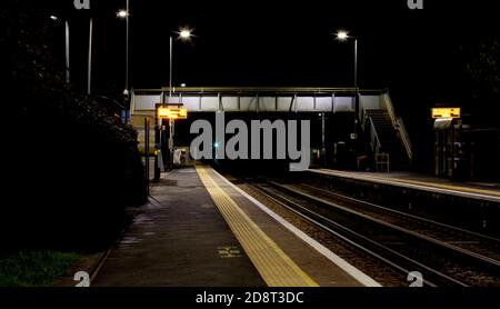 Ruhige, unbemannte britische Landbahnstation und Brücke in der Nacht Stockfoto