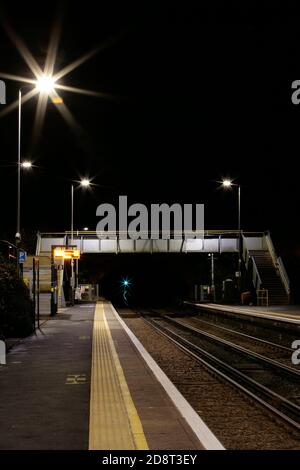 Ruhige, unbemannte britische Landbahnstation und Brücke in der Nacht Stockfoto