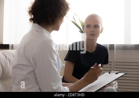 Nahaufnahme Arzt Schreiben haarlose Frau Beschwerden, Füllen Patientenkarte Stockfoto
