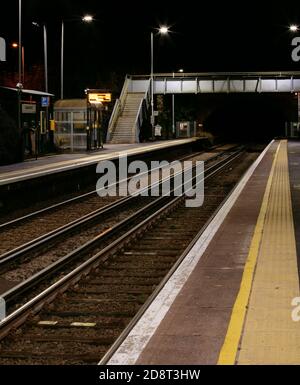 Ruhige, unbemannte britische Landbahnstation und Brücke in der Nacht Stockfoto