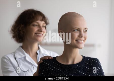 Nahaufnahme lächelnde haarlose Frau mit Arzt, der zur Seite schaut Stockfoto