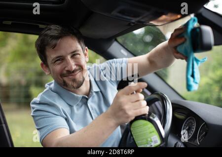 Mann mit Lappen Waschspiegel des Autos Stockfoto