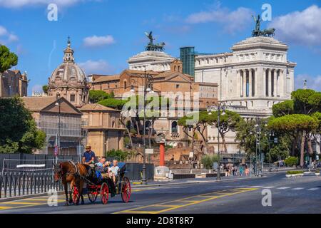 Stadt Rom in Italien, Touristen Familie auf Besichtigungstour in Pferdekutsche auf der Via dei Fori Imperiali Straße im historischen Stadtzentrum mit Altar von Th Stockfoto