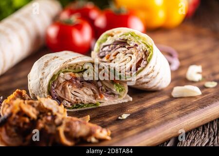 Schneiden Sie Tortilla Wrap mit Kebab Fleisch und Gemüse gefüllt Stockfoto