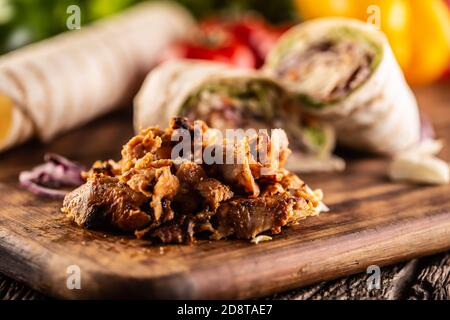 Späne von Shawarma mit gefüllten Tortillas im Hintergrund Stockfoto