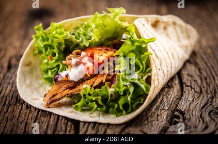 Tortilla mit Fleisch, Tomaten, Salat, Zwiebeln und Sahne Stockfoto