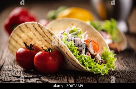 Offenes Fleisch und Gemüse Tortilla auf einem rustikalen Holzbrett Stockfoto