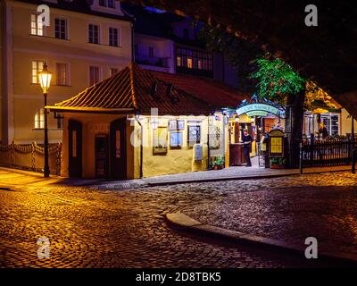 Blick auf ein mittelalterliches Restaurant unter dem Bogen von Chralesbrücke in Prag Stockfoto