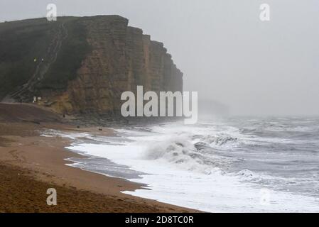 West Bay, Dorset, Großbritannien. November 2020. Wetter in Großbritannien. Der Strand ist fast menschenleer, als an einem nassen und windigen Nachmittag im Badeort West Bay in Dorset am letzten Tag der Schulhalbzeit große Wellen an Land krachen. Bild: Graham Hunt/Alamy Live News Stockfoto