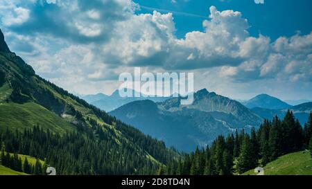 Deutschland, Allgäu, Breitenberg beeindruckende hohe Berge und grüne Bäume, die endlose Naturlandschaft mit bewölktem Himmel bedecken Stockfoto