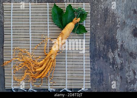 Frisches Ginseng auf Bambus-Webart mit dem Holz im Hintergrund Stockfoto