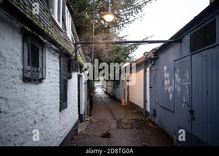 Leere Stadtgasse nach einem heftigen Regenguss gesehen. Dampf kommt aus den Küchen eines Restaurants zusammen mit einer Leih-Straßenlaterne. Stockfoto