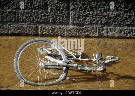 Fahrrad ertrunken in einem Stadtbach in Freiburg in Deutschland genannt Baechle, typische Merkmal dieser Stadt. Das Wasser fließt langsam und das Wasser ist flach. Stockfoto