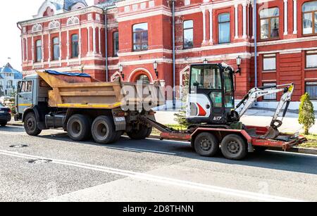 Samara, Russland - 29. Oktober 2020: Transport von kleinen Baggerlader auf einer Frachtplattform Stockfoto