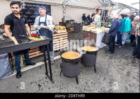 Samara, Russland - 5. Oktober 2019: Kochen appetitlichen Kebab auf Metall-Spieße über heiße Kohle. Traditionelle Küche in einem großen Kessel im Freien Stockfoto
