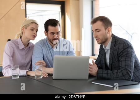 Qualifizierte junge männliche makler zeigt Online-Computer-Präsentation für Kunden. Stockfoto