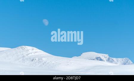 Berge im Winter mit dem aufgehenden Vollmond im Rondane Nationalpark, Norwegen Stockfoto