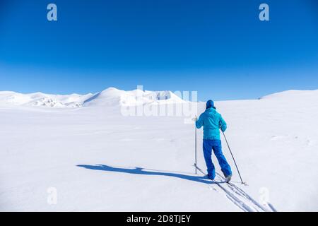 Mann auf Langlaufskiern in den Bergen bei Hovringen im Rondane Nationalpark, Norwegen Stockfoto