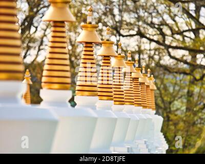 LA BOULAYE, FRANKREICH - APRIL CIRCA, 2018. Mehrere kleine weiße Stupas mit traditionellen Augen von Buddha Malerei in einer Reihe in tausend buddhas Tempel, EIN Stockfoto