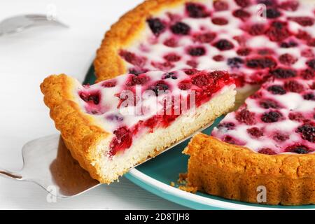 Nahaufnahme hausgemachte Beerentorte mit Himbeere und Brombeere auf weißem Holztisch. Geringer Fokus. Stockfoto