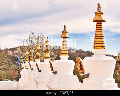 LA BOULAYE, FRANKREICH - APRIL CIRCA, 2018. Mehrere kleine weiße Stupas mit traditionellen Augen von Buddha Malerei in einer Reihe in tausend buddhas Tempel, EIN Stockfoto