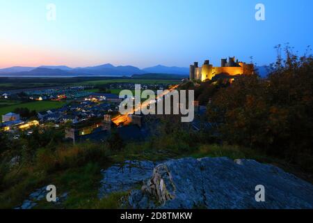 Harlech Castle in der Dämmerung mit den Bergen von Snowdonia in der Ferne. Wales, Großbritannien. Stockfoto