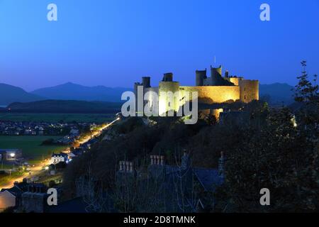 Harlech Castle in der Dämmerung mit den Bergen von Snowdonia in der Ferne. Wales, Großbritannien. Stockfoto