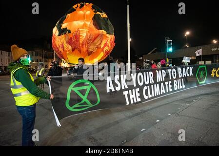 Hastings, Großbritannien. Oktober 2020. Extinction Rebellion Halloween Protest und März. Der lebhafte marsch verließ die Altstadt einmal dunkel, und schloss laute Samba Trommler, Skelette, hell erleuchtete Fahrräder, eine Welt im Feuer Bildnis, Feuer Fackeln und endete mit Rauchbomben. Die Straßen wurden durch 10M Banner blockiert, damit der marsch sicher Straßen überqueren konnte. Der Protest forderte sofortige und sinnvolle Maßnahmen der Regierung, um den Herausforderungen einer Klimanotlage zu begegnen. Veranstaltet von Extinction Rebellion Hastings / St. Leonards und Extinction Rebellion Southeast UK. Quelle: Stephen Bell/Alamy Stockfoto