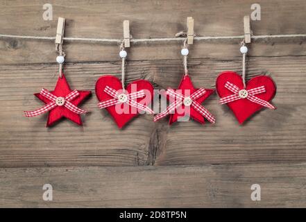 Weihnachtsschmuck Ornamente auf Schnur vor Holzhintergrund. Stockfoto