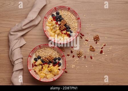 Gesunde Snacks in der Schüssel: Joghurt, Haferflocken, Apfel, Heidelbeeren, Walnüsse, Goji und Chiasamen. Superfood. Konzept der gesunden Ernährung, gesunde Lebensweise Stockfoto