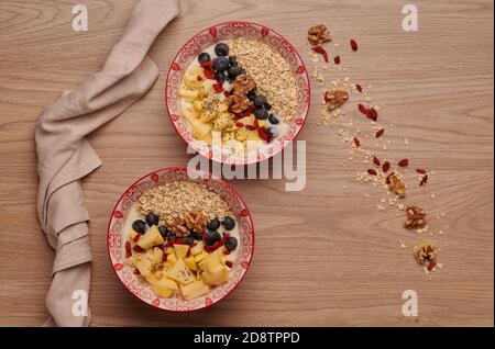 Gesunde Snacks in der Schüssel: Joghurt, Haferflocken, Apfel, Heidelbeeren, Walnüsse, Goji und Chiasamen. Superfood. Konzept der gesunden Ernährung, gesunde Lebensweise Stockfoto