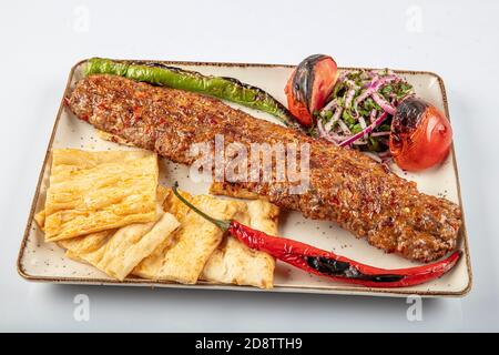 Türkischer Adana Kebab. Türkische Adana Kebab mit Gemüse auf dem Teller. Stockfoto