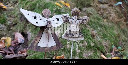 Schöne Engel Dekorationen mit Flügeln auf der Rückseite im Vintage-Garten. Engelsstatue gegen grünen moosigen Stein. Innen von verlassenen Garten mit Engel stat Stockfoto