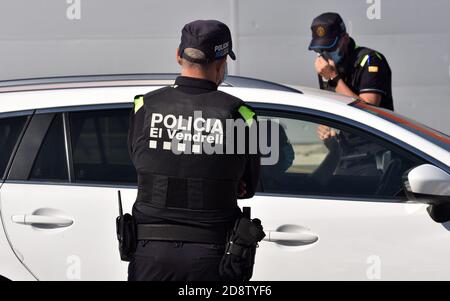 Vendrell, Spanien. März 2020. Lokale Polizeibeamte tragen Gesichtsmasken als Vorsichtsmaßnahme, um ein Fahrzeug an einem Kontrollpunkt während der Sperre zu überprüfen.die örtliche Polizei von Vendrell in Tarragona führt Polizeikontrollen durch, damit die neuen Maßnahmen erfüllt werden, um die Ansteckung der Covid-19-Pandemie zu stoppen. Die Regierung bestellt die Perimeter Schließung der autonomen Gemeinschaft Katalonien, ohne in der Lage zu geben oder zu verlassen, zusätzlich zu der Perimeter Schließung der Gemeinde, in der Sie von Freitag um 06:00 bis Montag um 06:00 wohnen, um Verschiebungen am Ende der Woche zu zweiten Wohnsitz zu vermeiden Stockfoto