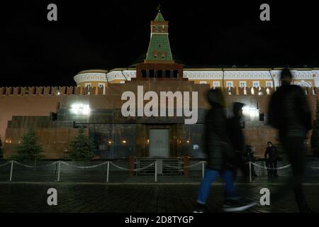 Die Schatten der Moskauer und der Touristen kommen am Mausoleum des Führers der Großen Sozialistischen Oktoberrevolution, Wladimir Lenin vorbei.spät abends in Moskau, im Herzen Russlands - auf dem Roten Platz, kommen die Menschen, wie die Schatten, an der jahrhundertealten Geschichte des Landes vorbei. Stockfoto