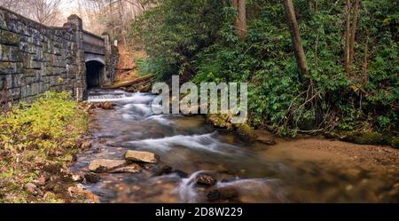 Kaskade fließt unter Steinbrücke im Pisgah National Forest - in der Nähe von Brevard, North Carolina USA [Panorama-Perspektive] Stockfoto