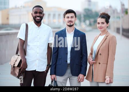 Drei junge erfolgreiche interkulturelle Geschäftspartner in smarter Casualwear Stockfoto