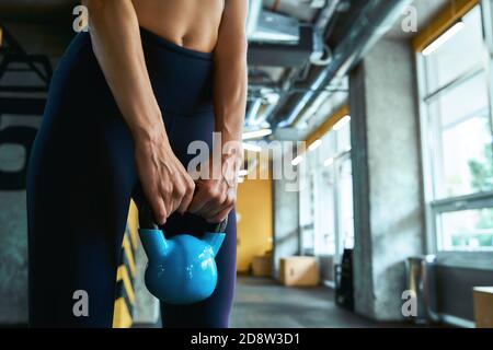 Krafttraining. Kurzer Schuss einer starken athletischen Frau beim Training mit Hantel in der industriellen Turnhalle, Training Arme. Sport, Training und gesunder Lebensstil Stockfoto