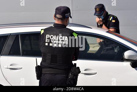 Lokale Polizeibeamte tragen Gesichtsmasken als Vorsichtsmaßnahme, um ein Fahrzeug an einem Kontrollpunkt während der Sperre zu überprüfen.die örtliche Polizei von Vendrell in Tarragona führt Polizeikontrollen durch, damit die neuen Maßnahmen erfüllt werden, um die Ansteckung der Covid-19-Pandemie zu stoppen. Die Regierung ordnet die Schließung der autonomen Gemeinschaft Katalonien an, ohne ein- oder ausreisen zu können, Zusätzlich zu der Perimeter Schließung der Gemeinde, in der Sie von Freitag um 06:00 bis Montag um 06:00 wohnen, um Verschiebungen am Ende der Woche zu Zweitwohnungen zu vermeiden, werden diese Einschränkungen 1 dauern Stockfoto