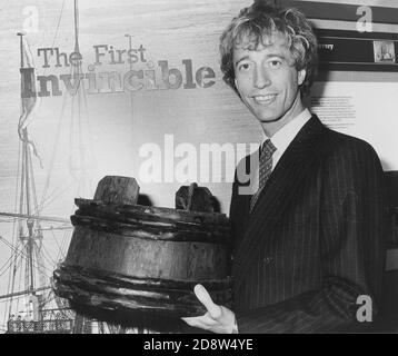 POPSTAR ROBIN GIBB VON DEN BIENEN GEES MIT EINEM 'SPIT KID' EINES DER RELIQUIEN AUS DEM WRACK DES MAN O WAR UNBESIEGBAR, DIE VOR PORTSMOUTH SANK IM JAHR 1758. PORTSMOUTH 1983 Stockfoto