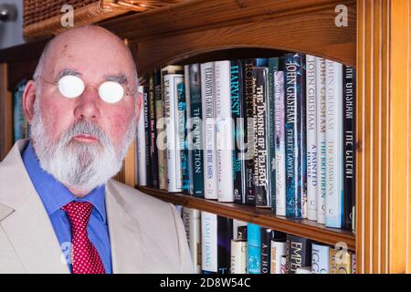 Porträt eines älteren Mannes in seinem Arbeitszimmer. Brillen absichtlich beleuchtet, um die Augen zu verbergen. Stockfoto