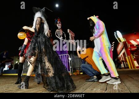 Los Angeles, USA. November 2020. Menschen in Kostümen feiern Halloween am 31. Oktober 2020 auf dem Santa Monica Pier in Los Angeles County, Kalifornien, USA. Mit Tür-zu-Tür-Trick oder Behandlung nicht empfohlen aufgrund COVID-19, Public Health Beamten erinnerte die Öffentlichkeit, dass es wichtig ist, richtig zu tragen Gesichtsbezüge, wie sie feiern Halloween. Quelle: Xinhua/Alamy Live News Stockfoto