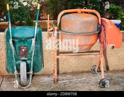 Schubkarre und Betonmischer bereit, auf einer Baustelle zu arbeiten. Stockfoto