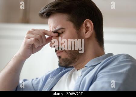 Müde männliche Reiben Brücke der Nase leiden Augenschmerzen Stockfoto